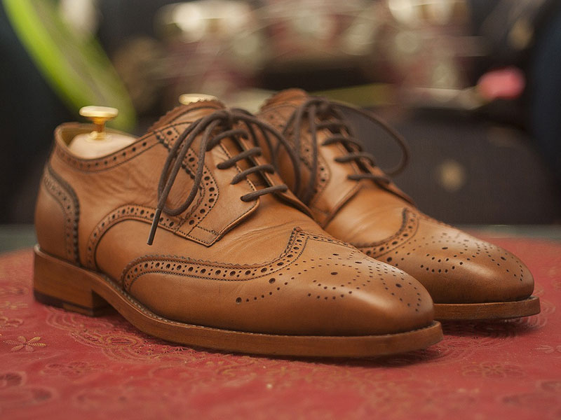 Brown leather dress shoes with brogue detailing, showcasing expert cleaning and restoration services for specialty items at Craft Cleaners.